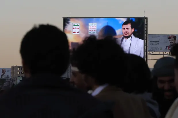 People gather in front of a digital billboard featuring Houthi leader Abdulmalik al-Houthi, in Sanaa, Yemen, 28 December 2025. (EPA)