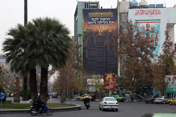 Iranians drive past an anti-Israeli billboard carrying a sentence in Persian reading "We are ready, are you ready?" hanging at Palestine Square in Tehran, Iran, 24 December 2025. (EPA)