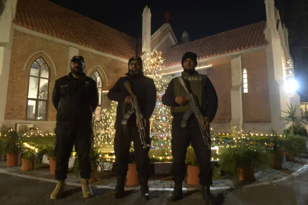 يقف رجال الشرطة حراساً خارج الكنيسة بينما يحضر أفراد من الأقلية المسيحية قداس عيد الميلاد في روالبندي بباكستان - 25 ديسمبر 2025 (إ.ب.أ)