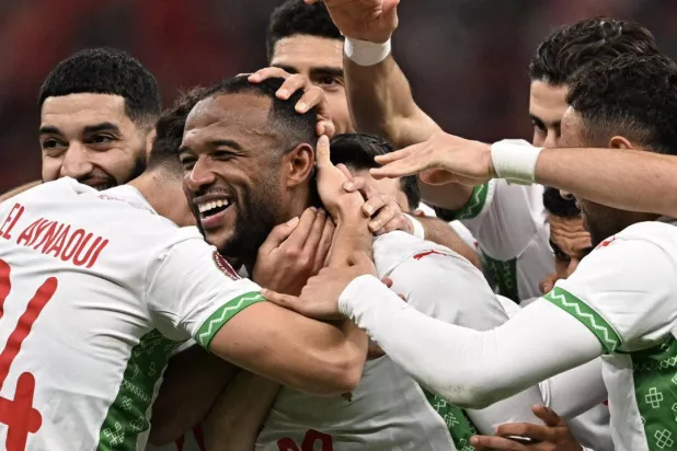 Ayoub El Kaabi is mobbed by teammates after scoring his second goal in Morocco's 3-0 win over Zambia. Gabriel BOUYS / AFP
