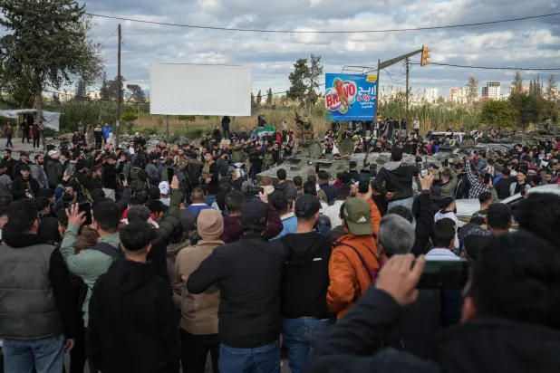 People watch as Syrian Security forces are deployed after clashes erupted during a protest in the city of Latakia, Syria, 28 December 2025. EPA/AHMAD FALLAHA 
