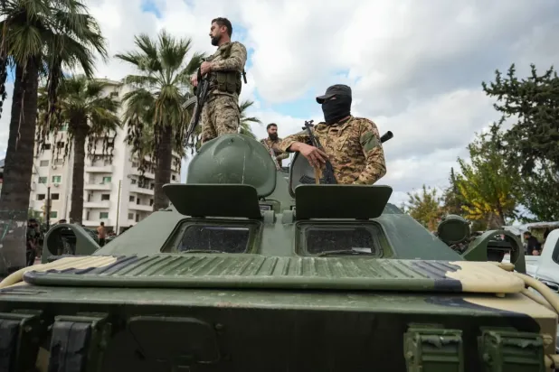 Suriye güvenlik güçleri Lazkiye kentindeki çatışmaların ardından bir askeri aracın üzerinde (EPA)