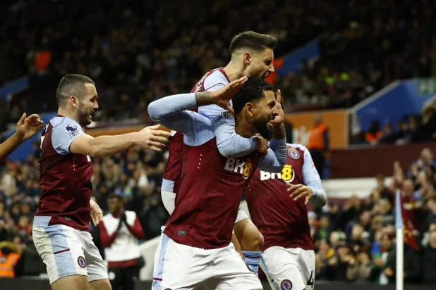 لاعبو أستون فيلا يحتفلون بأحد أهدافهم في الدوري (رويترز)