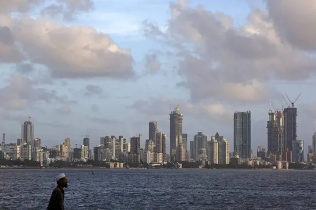  A man walks at the seafront as scattered clouds are seen over Mumbai's skyline, India, June 10, 2015. (Reuters)