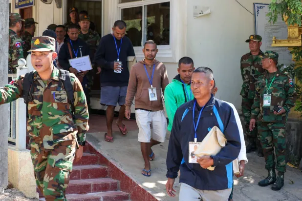 This handout photo taken and released by Agence Kampuchea Press (AKP) on December 31, 2025 shows Cambodian soldiers, who had been captured by Thai soldiers in July, being escorting by Cambodian soldiers after their release, as they walk at a checkpoint along the border with Thailand in Cambodia's Pailin province. (Ja Dina / Agence Kampuchea Press (AKP) / AFP) 