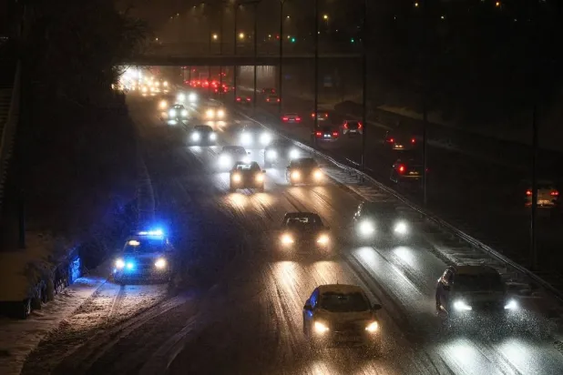 Cars drive on a road during heavy snowfall in central Warsaw, Poland, 30 December 2025. (EPA)