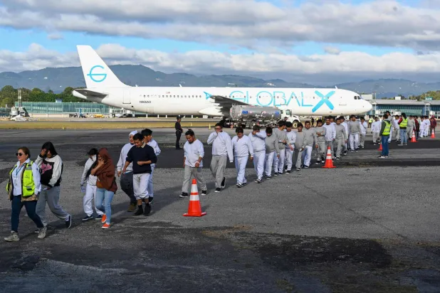 مهاجرون غواتيماليون مُرحّلون من الولايات المتحدة على مدرج مطار في مدينة غواتيمالا (أ.ف.ب)