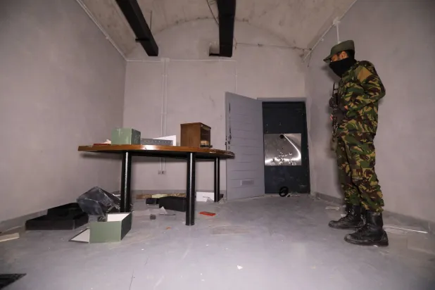 عنصر من قوات الأمن التابعة للسلطات السورية الجديدة في غرفة تحت الأرض بمكاتب ماهر الأسد على مشارف دمشق (أ.ف.ب)