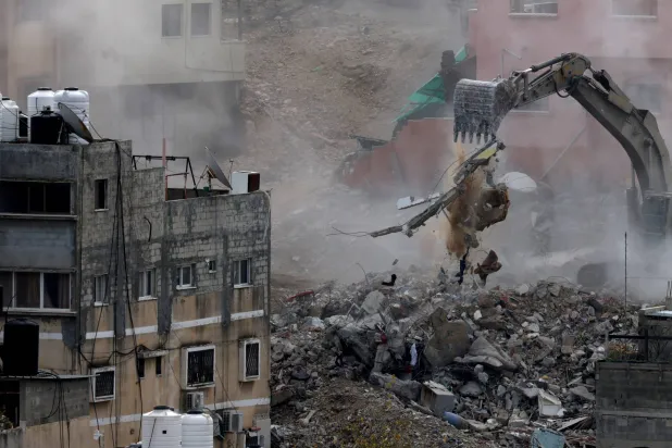 جرافة تابعة للجيش الإسرائيلي تهدم مباني خلال عملية عسكرية في مخيم نور شمس للاجئين (إ.ب.أ)