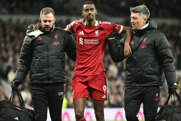 Liverpool's Swedish striker #09 Alexander Isak (C) is helped off the field by medical staff after picking up an injury during the English Premier League football match between Tottenham Hotspur and Liverpool at the Tottenham Hotspur Stadium in London, on December 20, 2025. (Photo by JUSTIN TALLIS / AFP)
