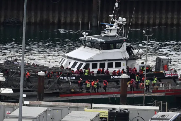 (FILES) Migrants picked up at sea attempting to cross the English Channel from France, disembark from Border Force vessel 'Ranger' after it arrived at the Marina in Dover, south-east England, on May 21, 2025. (Photo by Ben STANSALL / AFP)