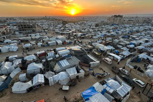 The sun sets over a tent camp sheltering Palestinians displaced by the Israeli offensive, on New Year’ Eve in Khan Younis, southern Gaza Strip, December 31, 2025. REUTERS/Ramadan Abed