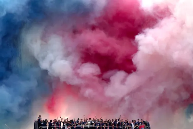 Fireworks explode as Paris Saint-Germain's players parade on a bus on the Champs-Elysees avenue in Paris on June 1, 2025, a day after PSG won the 2025 UEFA Champions League final football match against Inter Milan in Munich. (AFP)