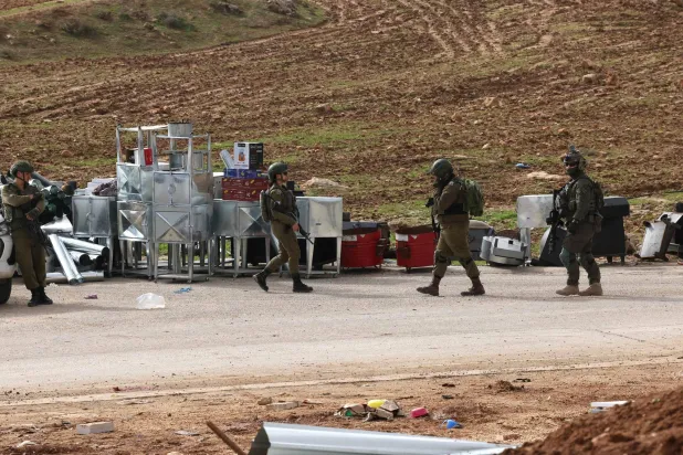 أفراد من قوات الأمن الإسرائيلية عند مدخل قرية السامو الفلسطينية المحتلة في الضفة الغربية بالقرب من مدينة الخليل أمس (أ.ف.ب)