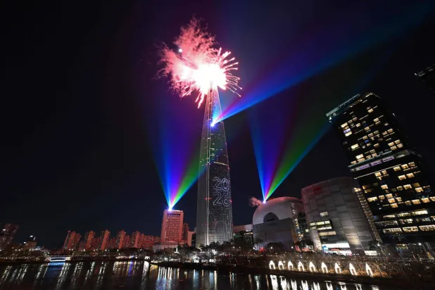 Fireworks light up the midnight sky over the Lotte World Tower, South Korea's tallest building in Seoul during New Year's Day celebrations on January 1, 2026. (Photo by Jung Yeon-je / AFP)