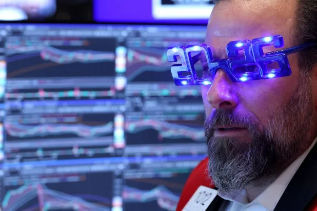 متداول يرتدي نظارات مكتوباً عليها «2026» خلال عمله في قاعة بورصة نيويورك (أ.ف.ب)
