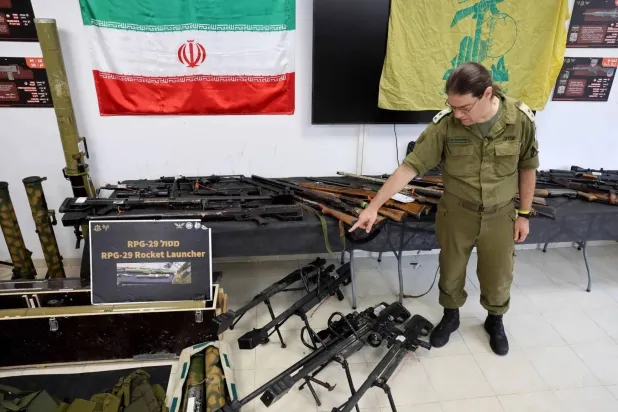 An Israeli officer displays weapons seized by the army in Gaza, Lebanon and Syria during a media tour (AFP). 