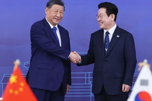 الرئيس الصيني شي جينبينغ ورئيس كوريا الجنوبية لي ​جيه-ميونغ في صورة من لقاء نوفمبر الماضي (أ.ف.ب) 