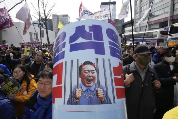 Protesters attend a rally calling for impeached South Korean President Yoon Suk Yeol to step down near the Constitutional Court in Seoul, South Korea, Monday, March 17, 2025. The letters read "Arrest Yoon Suk Yeol " (AP Photo/Ahn Young-joon)