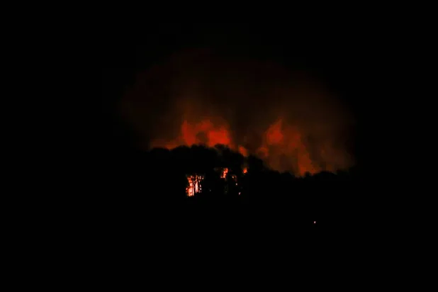 الدخان يتصاعد قرب حصن تيونا -وهي منطقة عسكرية- خلال انقطاع تام للتيار الكهربائي عقب انفجارات وأصوات مدوية في كاراكاس (رويترز)