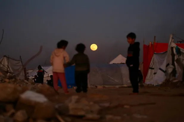  The first supermoon of the year, the "Wolf Moon," is seen rising over Bureij refugee camp, in the central Gaza Strip on January 3, 2026. (AFP) 