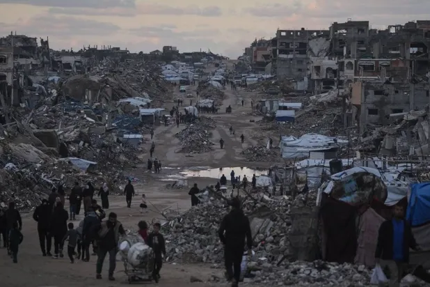  Palestinians walk past destroyed buildings in the northern Gaza Strip, Friday, Jan. 2, 2026. (AP) 