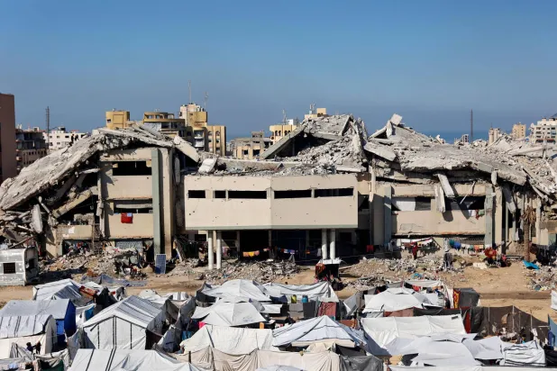 تجمُّع لخيام النازحين الفلسطينيين أمام المباني المدمَّرة للجامعة الإسلامية في مدينة غزة (أ.ف.ب)