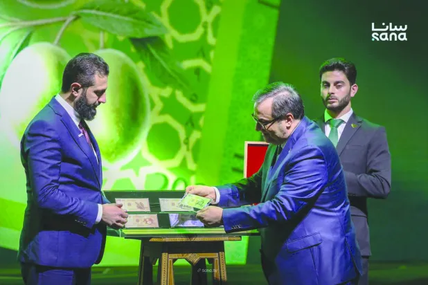 الرئيس السوري أحمد الشرع وحاكم مصرف سوريا المركزي عبد القادر الحصرية خلال إطلاق العملة السورية الجديدة (سانا)