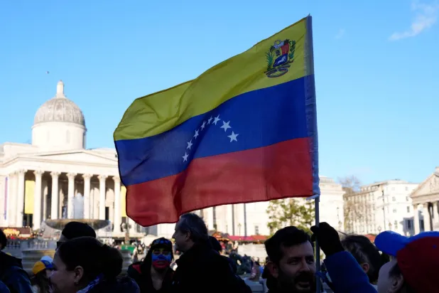 A person holds a Venezuelan flag during a rally calling for a democratic transition in Venezuela, the day after US President Donald Trump said the US has taken control of the country following a raid that captured Venezuelan President Nicolas Maduro, at Trafalgar Square in London, Britain January 4, 2026. (Reuters)