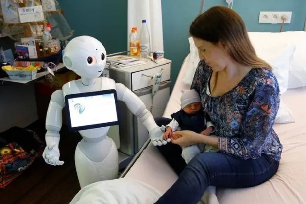 الروبوت «بيبر» يستقبل الزوار ويراعي المرضى بمستشفى في بلجيكا (رويترز)