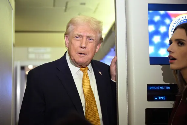 US President Donald Trump speaks with reporters aboard Air Force One on his way back to Washington, DC, on January 4, 2026. (Photo by Jim WATSON / AFP)