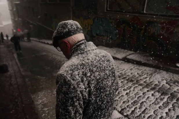 شخص يسير في الشارع خلال أول تساقط للثلوج هذا العام بإسطنبول (أ.ب)