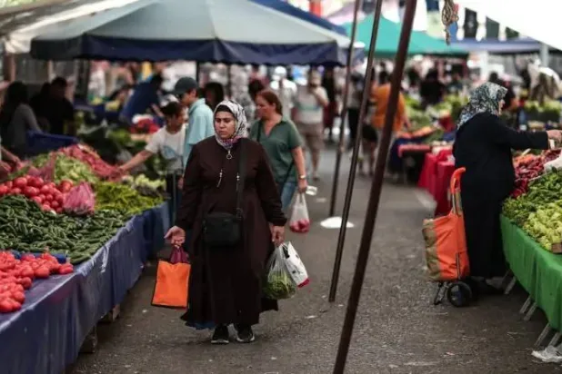 متسوقون داخل سوق للخضراوات والفاكهة في إسطنبول (إ.ب.أ)