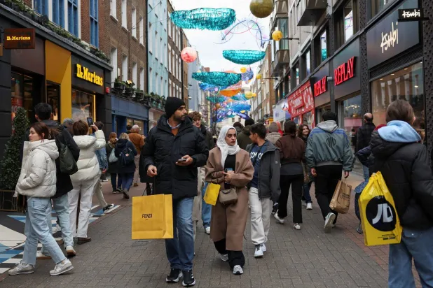 متسوقون يسيرون في شارع كارنابي خلال تخفيضات يوم «بوكسينغ داي» في لندن (رويترز)