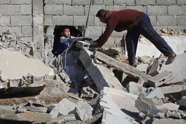 فلسطينيون يبحثون عن متعلقاتهم يوم الاثنين بين أنقاض مبنى دمرته إسرائيل في مخيم المغازي وسط غزة (أ.ف.ب)