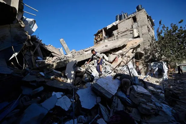 A Palestinian boy looks for his belongings amid the debris of a collapsed house that was previously damaged by an Israeli strike, at the Maghazi refugee camp in the central of Gaza Strip on January 5, 2026. (AFP)