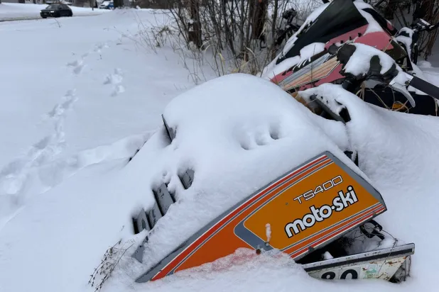 Fresh snow covers old snowmobiles on display in Lowville, N.Y,, on Saturday, Dec. 27, 2025.  (AP Photo/Cara Anna)