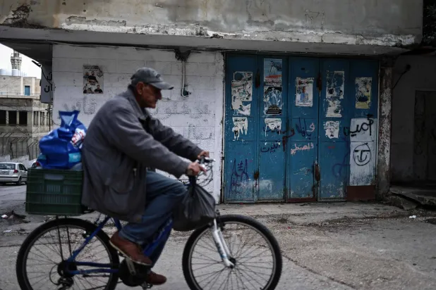  A man rides his bicycle at the Balata camp for Palestinian refugees, east of Nablus in the occupied West Bank on December 30, 2025. (AFP) 