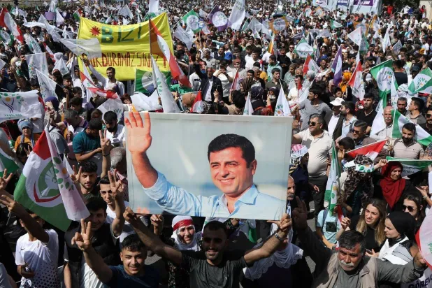 أكراد يرفعون صورة للسياسي الكردي صلاح الدين دميرطاش خلال مظاهرة في جنوب شرقي تركيا للمطالبة بإطلاق سراحه (رويترز)