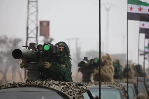 جنود من الجيش السوري وبحوزتهم قاذف مضاد للدروع خلال عرض عسكري بحلب في الذكرى الأولى للإطاحة بحكم الرئيس بشار الأسد («الدفاع» السورية)