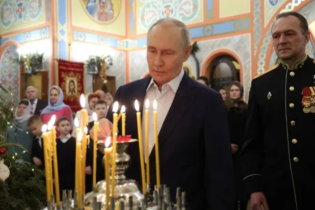 Putin, Moskova yakınlarındaki St. George Kilisesi'nde düzenlenen ayin sırasında üniformalı askerlerin arasında kravatsız koyu renkli bir ceket giyerken (DPA)