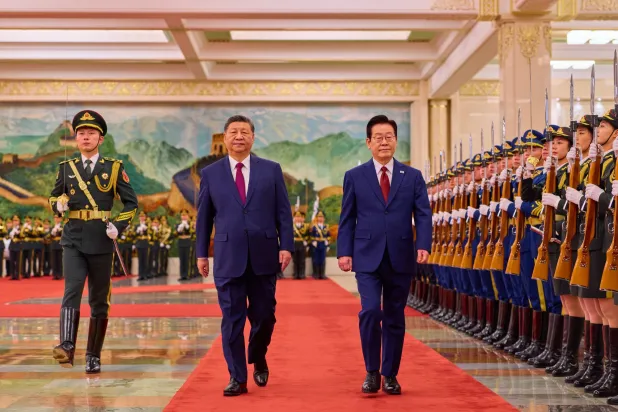 الرئيس الصيني شي جينبينغ والرئيس الكوري الجنوبي لي جاي ميونغ يتفقدان حرس الشرف خلال حفل استقبال في بكين (أ.ب)