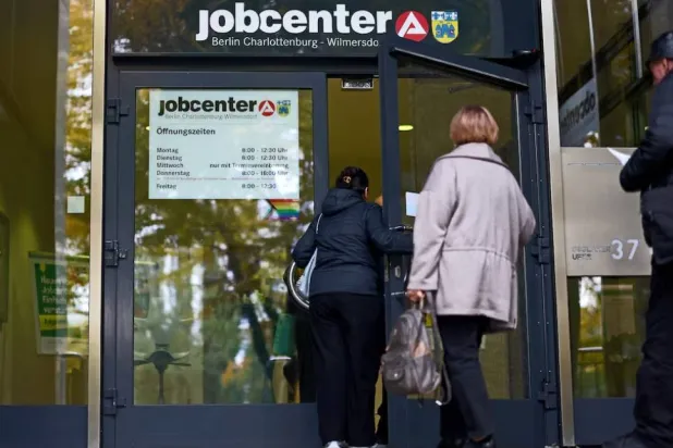 أشخاص يدخلون مركز توظيف في برلين (رويترز)