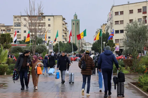 Passengers walk in front of Fes Railway Station, decorated with Africa Cup of Nations (AFCON) theme colors and flags, in the Moroccan city of Fes, January 5, 2026. (Reuters)