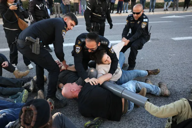 اعتقلت الشرطة الإسرائيلية متظاهرين مناهضين للحكومة قاموا بتقييد أنفسهم بالسلاسل في محاولة لإغلاق الطريق الرئيسي أمام المحكمة العليا الإسرائيلية في القدس (إ.ب.أ)