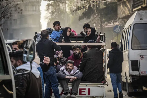 Gazze Şeridi'nin orta kesimindeki el-Meğazi Mülteci Kampı’nda, İsrail hava saldırıları sonucu enkaz yığınına dönüşen bir evin kalıntıları arasında eşya arayan çocuklar (AFP)