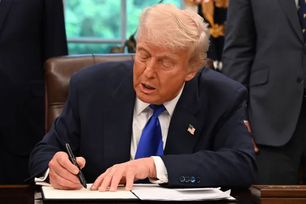 الرئيس الأميركي دونالد ترمب يوقع على أوامر تنفيذية في المكتب البيضاوي بالبيت الأبيض (أ.ف.ب)