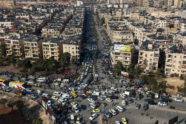 صورة جوية تُظهر سكاناً سوريين في سيارات يصطفون للفرار من حيي الشيخ مقصود والأشرفية (أ.ب)