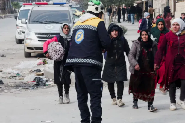 Civilians carry their bags and belongings as they flee following renewed clashes between the Syrian army and the Syrian Democratic Forces, in Aleppo, Syria, January 8, 2026. REUTERS/Mahmoud Hassano 