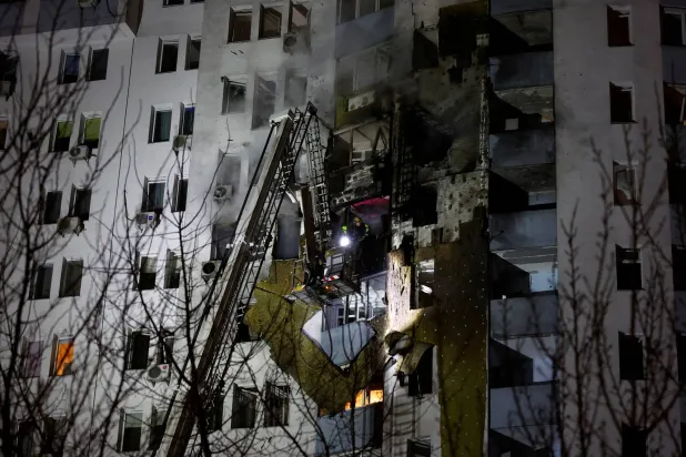 رجال إطفاء في موقع تعرض لغارة روسية بطائرة مسيرة في كييف (رويترز)